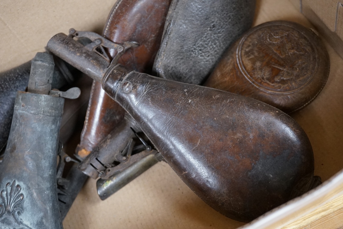 Three gun-sized copper powder flasks, two of which are embossed, together with four leather shot bags each with sprung chargers, two iron and two brass examples, one of which is embossed with a hunting scene (7)